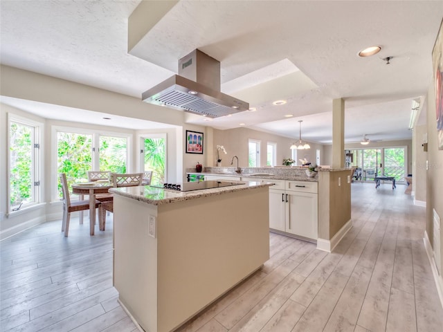 123 Tidy Island Blvd, Bradenton, FL 34210 - kitchen featuring ventilation hood, a center island, light wood-style floors, black electric stovetop, and white cabinets