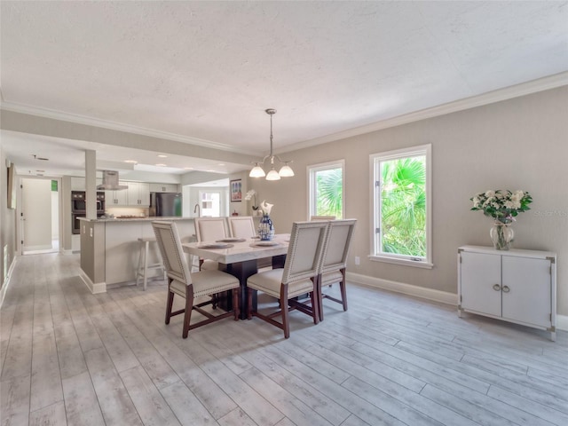 123 Tidy Island Blvd, Bradenton, FL 34210 - dining room with light wood-style flooring, crown molding, and a chandelier