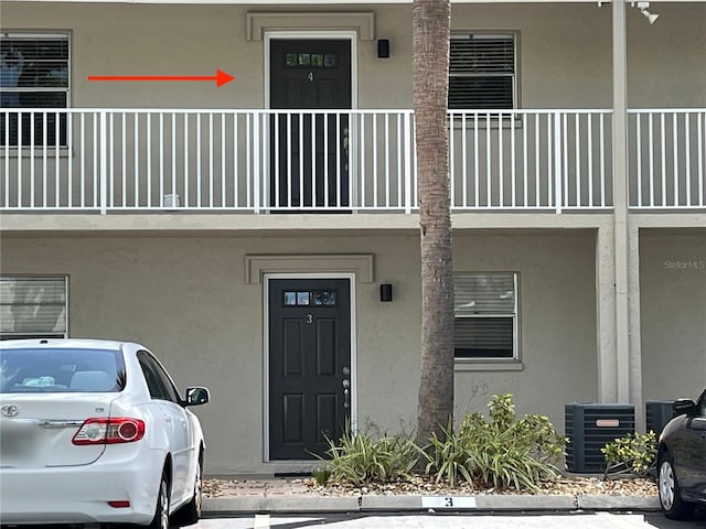 900 La Costa Cir Unit 4, Sarasota, FL 34237 - view of exterior entry with stucco siding and a balcony