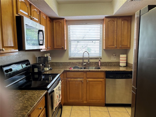 900 La Costa Cir Unit 4, Sarasota, FL 34237 - kitchen with appliances with stainless steel finishes, brown cabinetry, and light tile patterned flooring