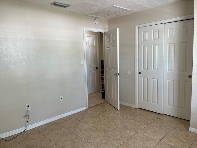 900 La Costa Cir Unit 4, Sarasota, FL 34237 - unfurnished bedroom with light tile patterned floors, a closet, and a textured ceiling