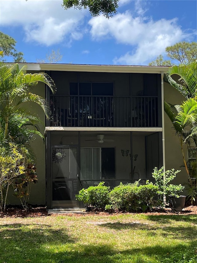 900 La Costa Cir Unit 4, Sarasota, FL 34237 - back of house featuring stucco siding, a lawn, and a balcony