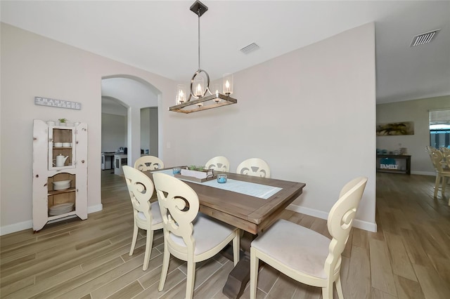 16231 Tradewind Ter, Bradenton, FL 34211 - dining area with light wood-type flooring, a chandelier, and arched walkways