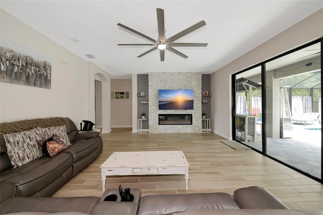 16231 Tradewind Ter, Bradenton, FL 34211 - living area featuring ceiling fan, wood finished floors, a fireplace, and arched walkways