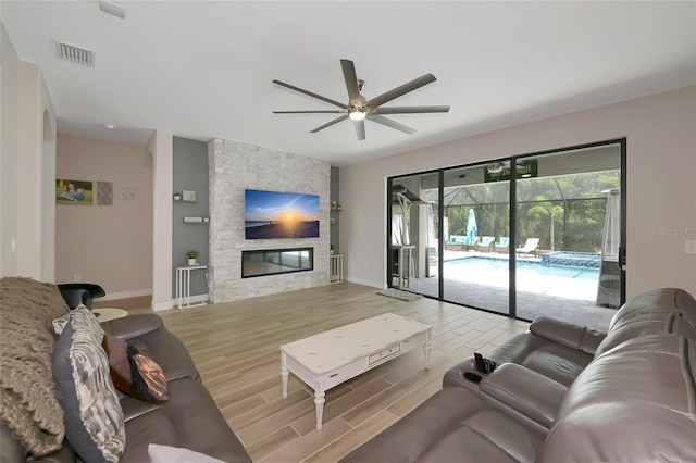 16231 Tradewind Ter, Bradenton, FL 34211 - living room with ceiling fan, wood finished floors, and a fireplace