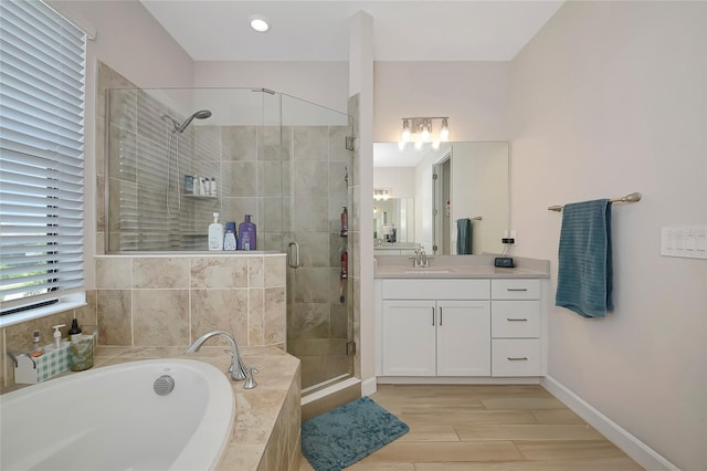 16231 Tradewind Ter, Bradenton, FL 34211 - bathroom featuring a bath, vanity, a stall shower, and wood finished floors