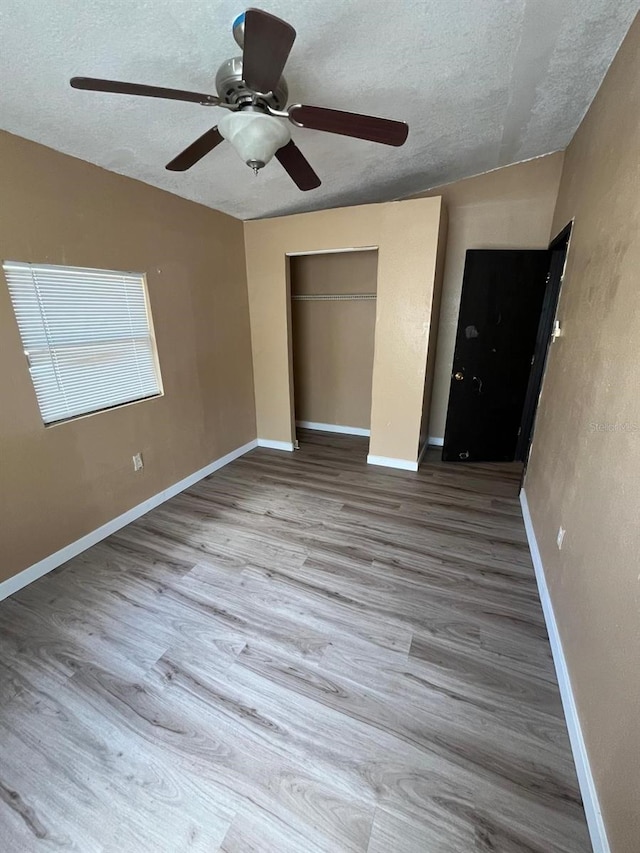 507 Cloudcroft Dr, Deltona, FL 32738 - unfurnished bedroom featuring a textured ceiling, a closet, wood finished floors, and ceiling fan