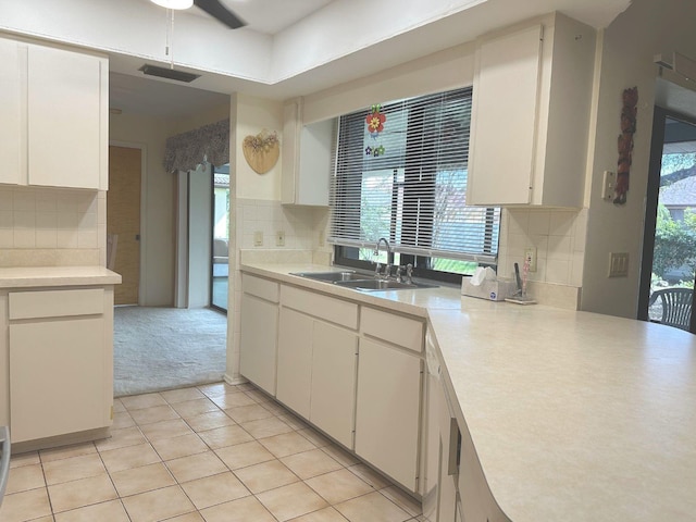 22321 Yonkers Ave, Port Charlotte, FL 33952 - kitchen featuring decorative backsplash, light countertops, light tile patterned floors, and white cabinets