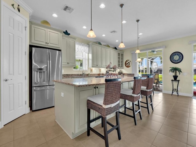 2749 Lambay Ct, Cape Coral, FL 33991 - kitchen with stainless steel fridge with ice dispenser, a kitchen island, light tile patterned floors, a kitchen bar, and recessed lighting