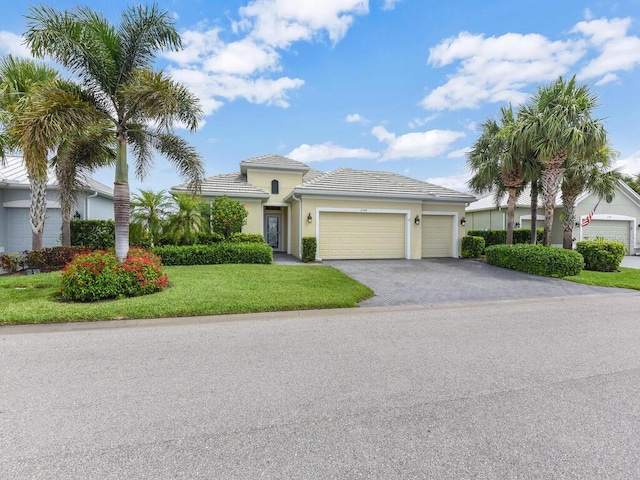 2749 Lambay Ct, Cape Coral, FL 33991 - view of front of home featuring an attached garage, a front yard, driveway, stucco siding, and a tiled roof