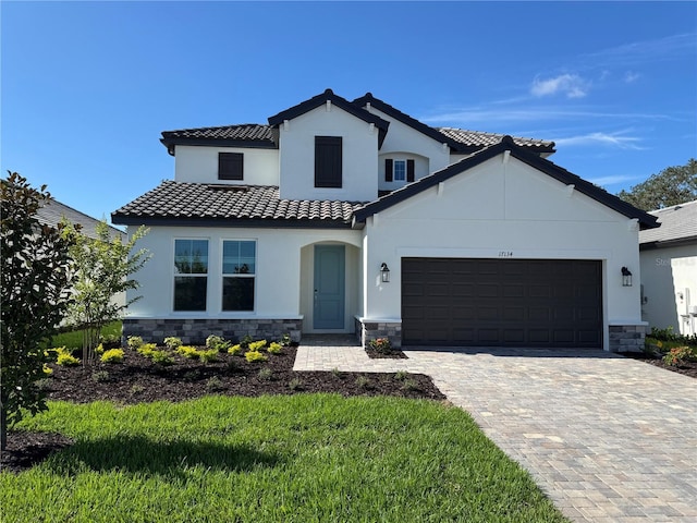 17134 Savory Mist Cir, Bradenton, FL 34211 - mediterranean / spanish-style home featuring stone siding, an attached garage, stucco siding, and decorative driveway
