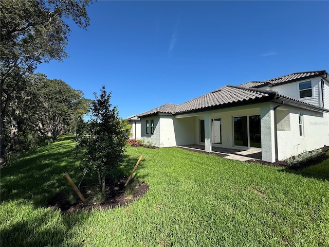 17134 Savory Mist Cir, Bradenton, FL 34211 - back of property with stucco siding, a yard, and a tile roof