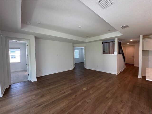 17134 Savory Mist Cir, Bradenton, FL 34211 - unfurnished room featuring a raised ceiling, a textured ceiling, plenty of natural light, dark wood finished floors, and recessed lighting