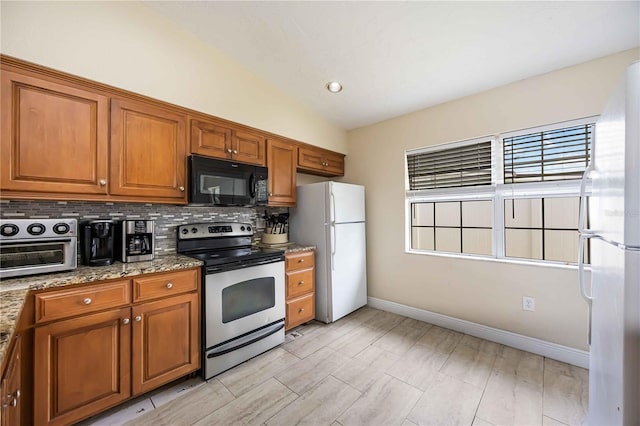 3641 Stokes Dr, Sarasota, FL 34232 - kitchen featuring electric range, black microwave, freestanding refrigerator, and brown cabinets