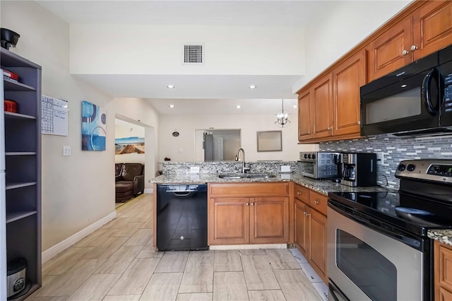 3641 Stokes Dr, Sarasota, FL 34232 - kitchen with black appliances, a peninsula, brown cabinets, stone counters, and recessed lighting