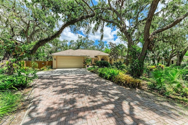3217 Oak Grove Dr, Sarasota, FL 34243 - view of front facade with an attached garage, decorative driveway, and stucco siding