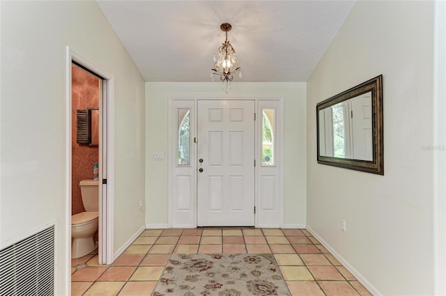 3217 Oak Grove Dr, Sarasota, FL 34243 - foyer featuring light tile patterned flooring and a chandelier