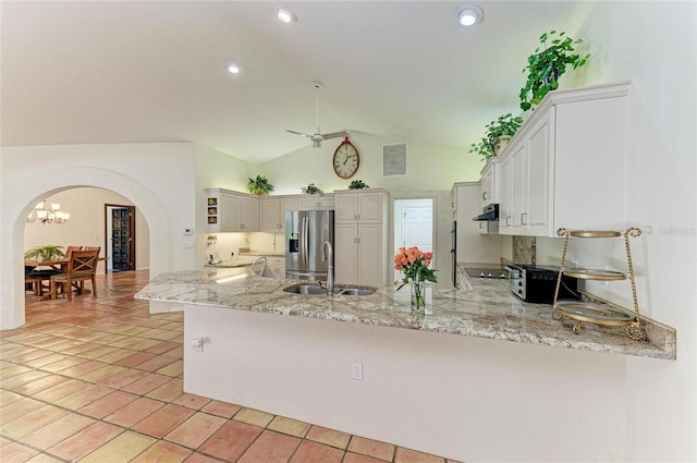 3217 Oak Grove Dr, Sarasota, FL 34243 - kitchen featuring arched walkways, stainless steel refrigerator with ice dispenser, a peninsula, range hood, and lofted ceiling
