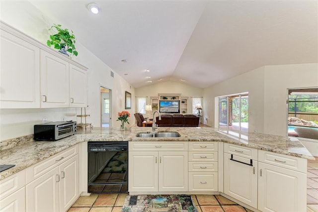 3217 Oak Grove Dr, Sarasota, FL 34243 - kitchen with black dishwasher, vaulted ceiling, open floor plan, white cabinets, and a peninsula