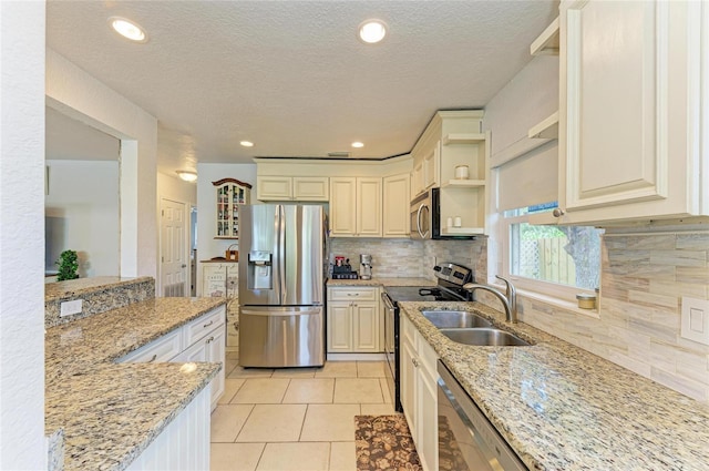 5415 13th Avenue Dr W, Bradenton, FL 34209 - kitchen featuring stainless steel appliances, open shelves, light stone countertops, tasteful backsplash, and a textured ceiling