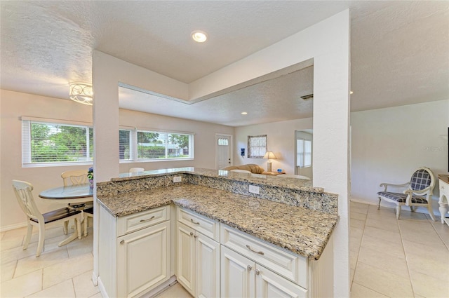 5415 13th Avenue Dr W, Bradenton, FL 34209 - kitchen featuring a textured ceiling, light stone counters, light tile patterned floors, open floor plan, and recessed lighting