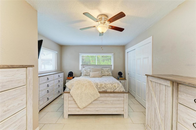5415 13th Avenue Dr W, Bradenton, FL 34209 - bedroom featuring light tile patterned floors, a closet, a ceiling fan, and a textured ceiling