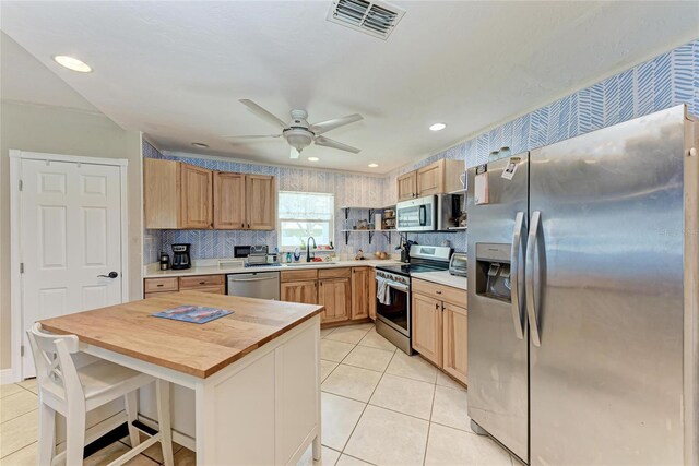 2406 15th St W, Palmetto, FL 34221 - kitchen with stainless steel appliances, wood counters, light tile patterned floors, tasteful backsplash, and recessed lighting