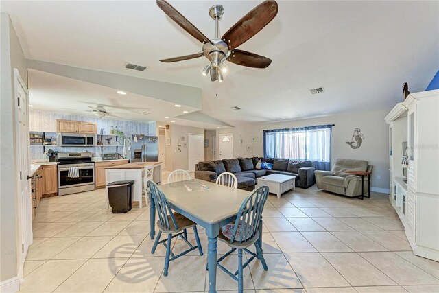 2406 15th St W, Palmetto, FL 34221 - dining room featuring a ceiling fan, light tile patterned flooring, and vaulted ceiling