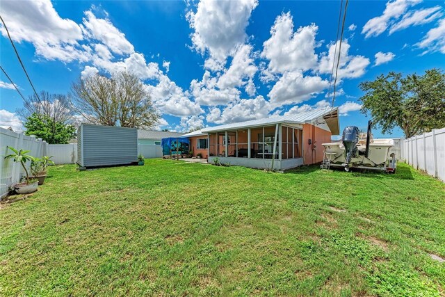 2406 15th St W, Palmetto, FL 34221 - rear view of property featuring a sunroom, a shed, and a fenced backyard