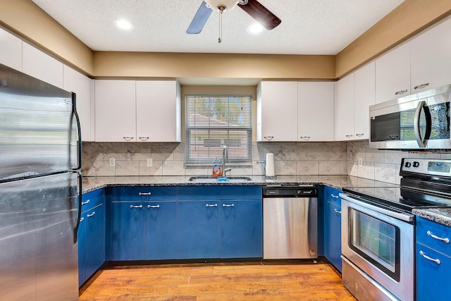 2315 Riverwood Pines Dr, Sarasota, FL 34231 - kitchen featuring stainless steel appliances, blue cabinets, white cabinets, dark stone counters, and recessed lighting