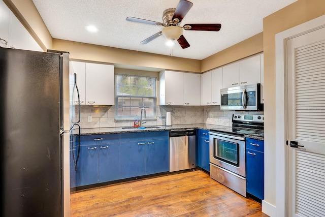 2315 Riverwood Pines Dr, Sarasota, FL 34231 - kitchen featuring stainless steel appliances, blue cabinets, ceiling fan, white cabinetry, and light wood-style flooring