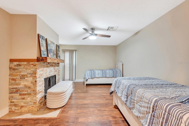 2315 Riverwood Pines Dr, Sarasota, FL 34231 - bedroom featuring wood finished floors, ceiling fan, and a fireplace
