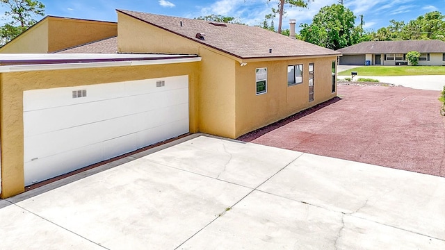 2315 Riverwood Pines Dr, Sarasota, FL 34231 - view of side of property with stucco siding, driveway, and a shingled roof