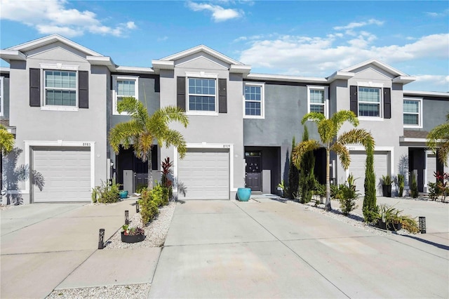 8979 Milestone Dr, Sarasota, FL 34238 - townhome / multi-family property with an attached garage, stucco siding, and driveway