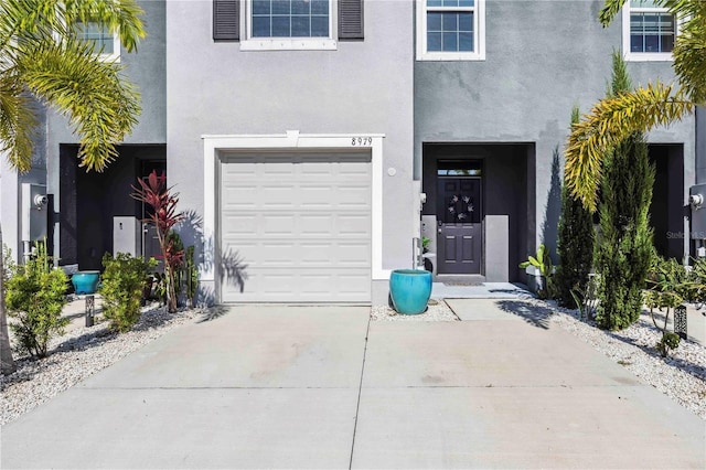 8979 Milestone Dr, Sarasota, FL 34238 - doorway to property featuring stucco siding, concrete driveway, and an attached garage