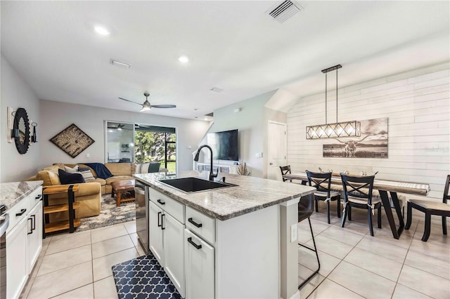 8979 Milestone Dr, Sarasota, FL 34238 - kitchen with open floor plan, a ceiling fan, light tile patterned floors, white cabinets, and light stone countertops
