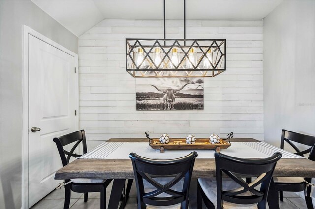 8979 Milestone Dr, Sarasota, FL 34238 - dining room featuring wood walls, tile patterned flooring, and lofted ceiling