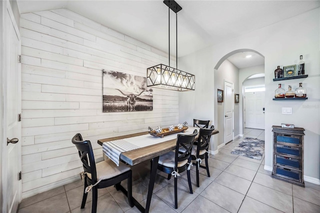 8979 Milestone Dr, Sarasota, FL 34238 - dining space with arched walkways, wood walls, and light tile patterned floors
