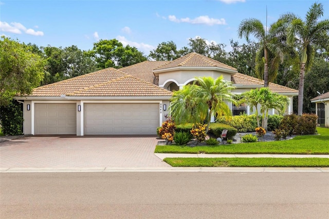 8840 Brookfield Ter, Bradenton, FL 34212 - mediterranean / spanish-style home with driveway, stucco siding, a tiled roof, and a garage