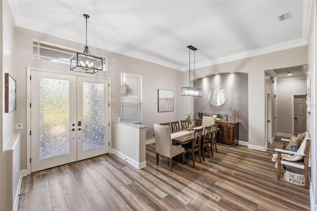 8840 Brookfield Ter, Bradenton, FL 34212 - dining room featuring french doors, wood finished floors, crown molding, and a chandelier