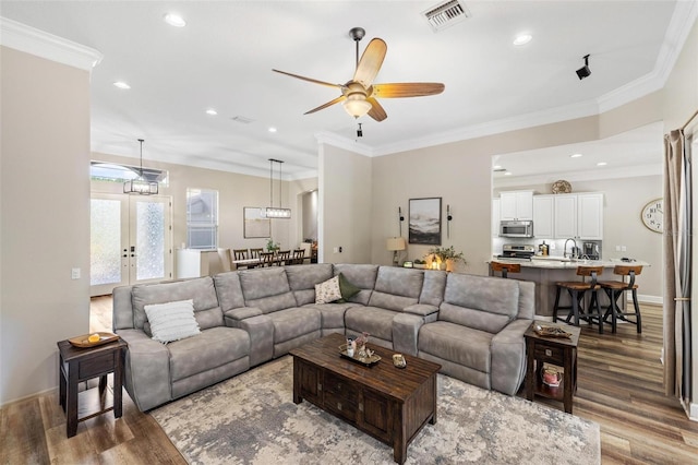 8840 Brookfield Ter, Bradenton, FL 34212 - living area with wood finished floors, a ceiling fan, recessed lighting, crown molding, and french doors