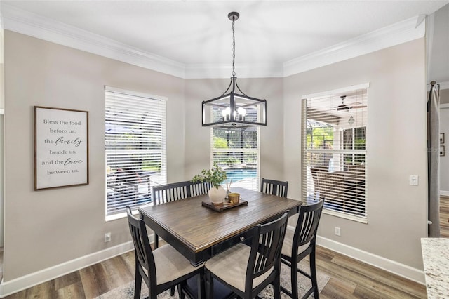 8840 Brookfield Ter, Bradenton, FL 34212 - dining area with a chandelier, dark wood finished floors, and crown molding
