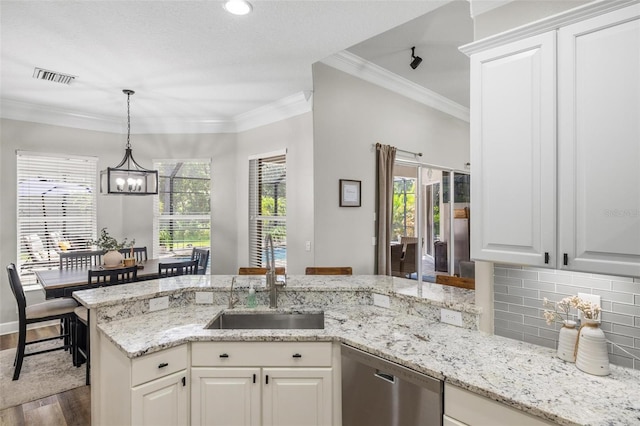 8840 Brookfield Ter, Bradenton, FL 34212 - kitchen with stainless steel dishwasher, wood finished floors, a chandelier, light stone countertops, and ornamental molding