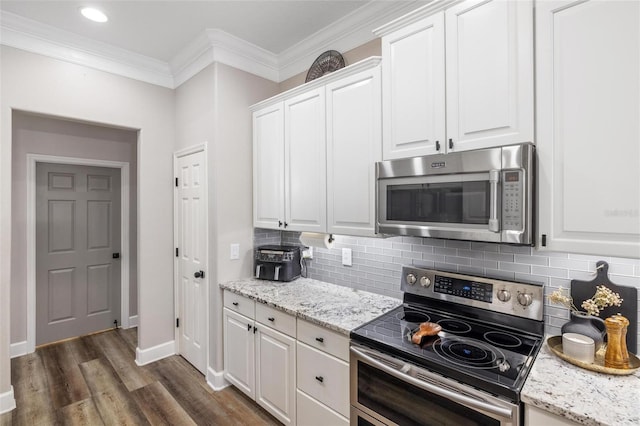 8840 Brookfield Ter, Bradenton, FL 34212 - kitchen featuring stainless steel appliances, backsplash, white cabinets, crown molding, and dark wood-style floors
