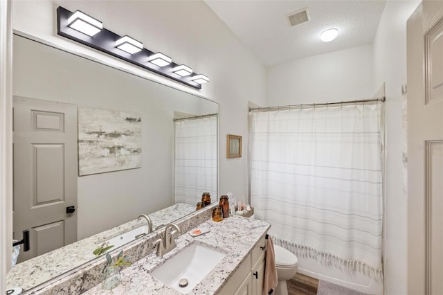 8840 Brookfield Ter, Bradenton, FL 34212 - bathroom featuring vanity, shower / bath combo, a textured ceiling, and wood finished floors