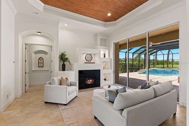 7144 Ashland Gln, Lakewood Ranch, FL 34202 - living room featuring a raised ceiling, a sunroom, ornamental molding, light tile patterned flooring, and a glass covered fireplace