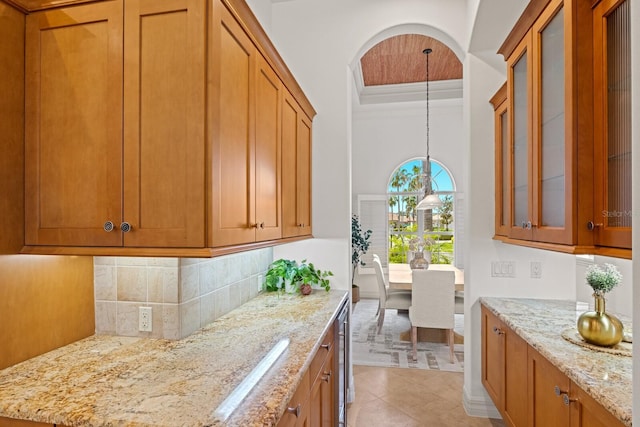 7144 Ashland Gln, Lakewood Ranch, FL 34202 - kitchen with brown cabinetry, light stone counters, and decorative backsplash