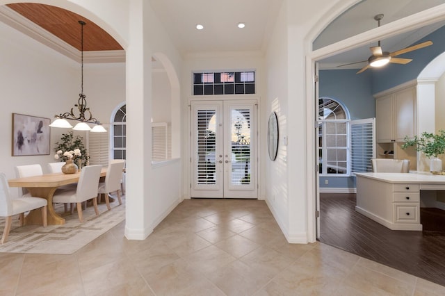 7144 Ashland Gln, Lakewood Ranch, FL 34202 - foyer entrance with french doors, a high ceiling, crown molding, a ceiling fan, and light tile patterned flooring