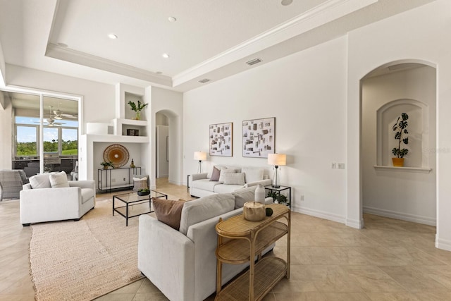 7144 Ashland Gln, Lakewood Ranch, FL 34202 - living room with arched walkways, built in shelves, light tile patterned flooring, a tray ceiling, and recessed lighting