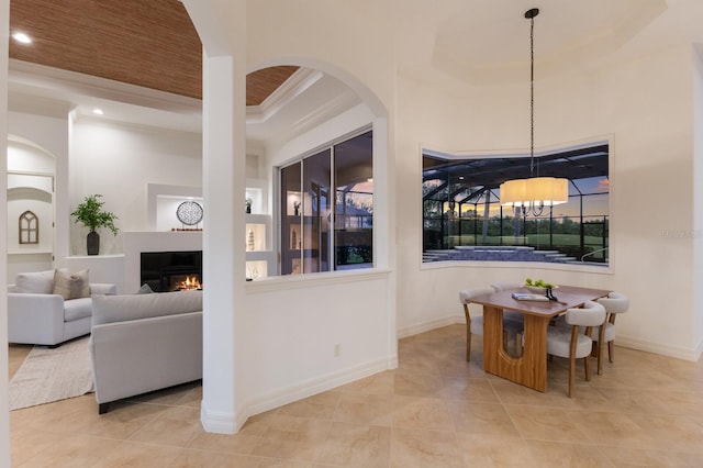 7144 Ashland Gln, Lakewood Ranch, FL 34202 - dining room featuring ornamental molding, a glass covered fireplace, a chandelier, tile patterned flooring, and recessed lighting